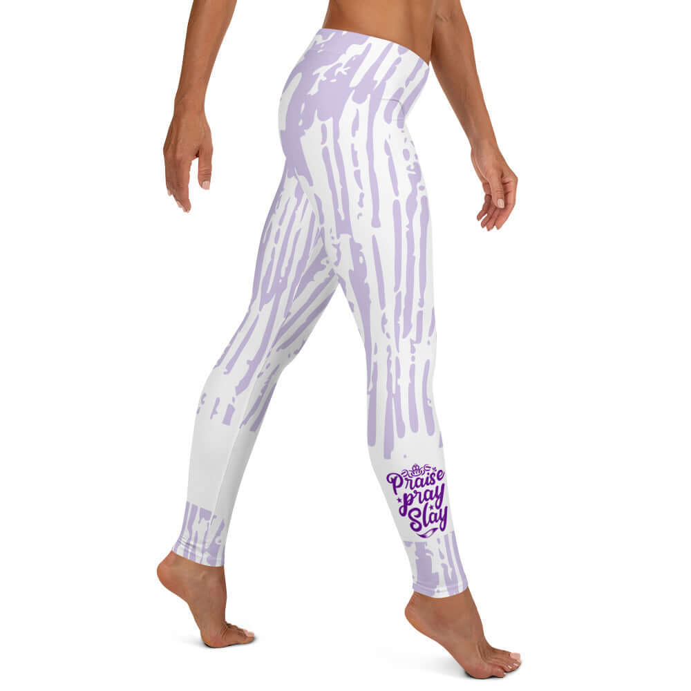 Right view of purple and white print leggings with purple text around bottom leg saying 'Praise Pray Slay'