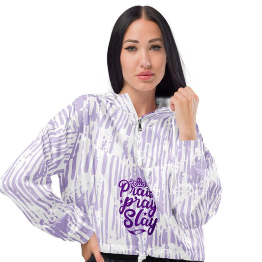 Front view of woman wearing a cropped purple and white with text saying Praise Pray Slay windbreaker