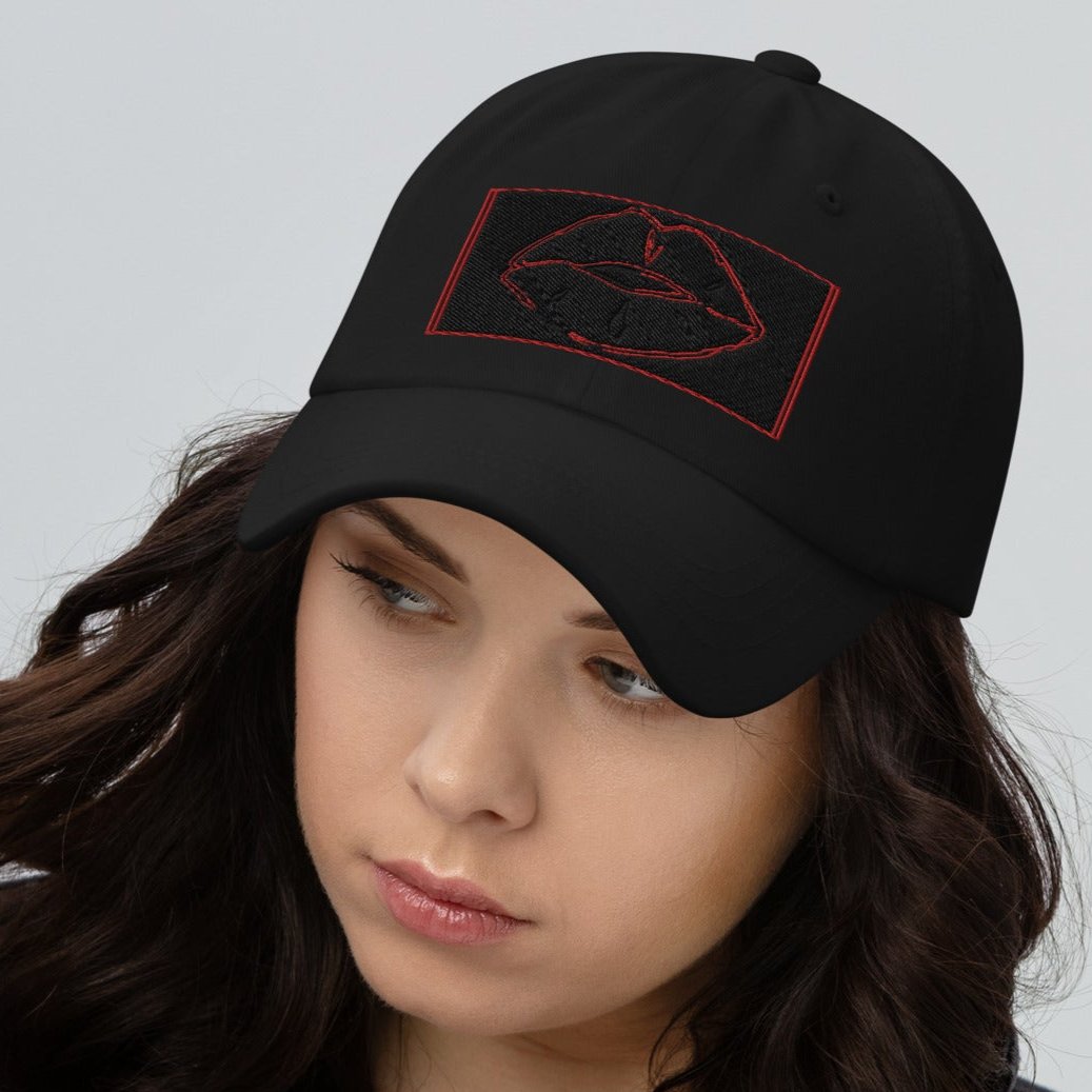 Front zoomed of black cap with red and black image of lips on front