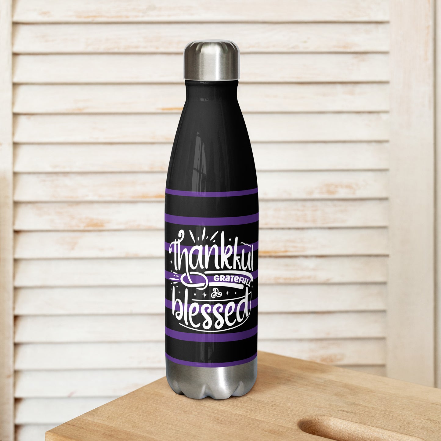 Front view of a black 17 oz stainless steel water bottle with purple and white lines and white text saying 'Thankful and blessed'