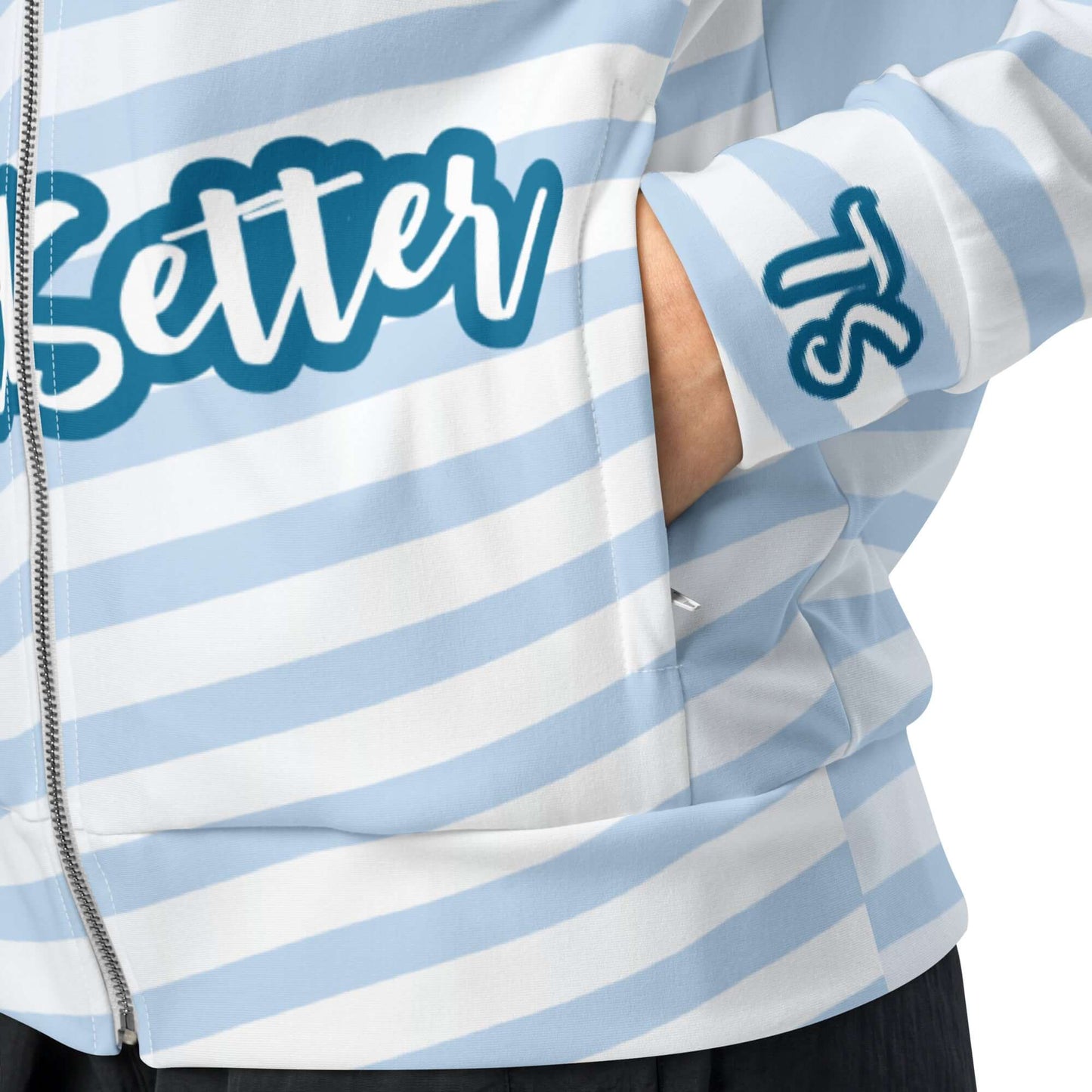 Left pocket view of TrendSetter light blue and white track jacket with white stripes across the bottom and blue and white text saying 'TrendSetter' across the front, 'TS' on the cuff