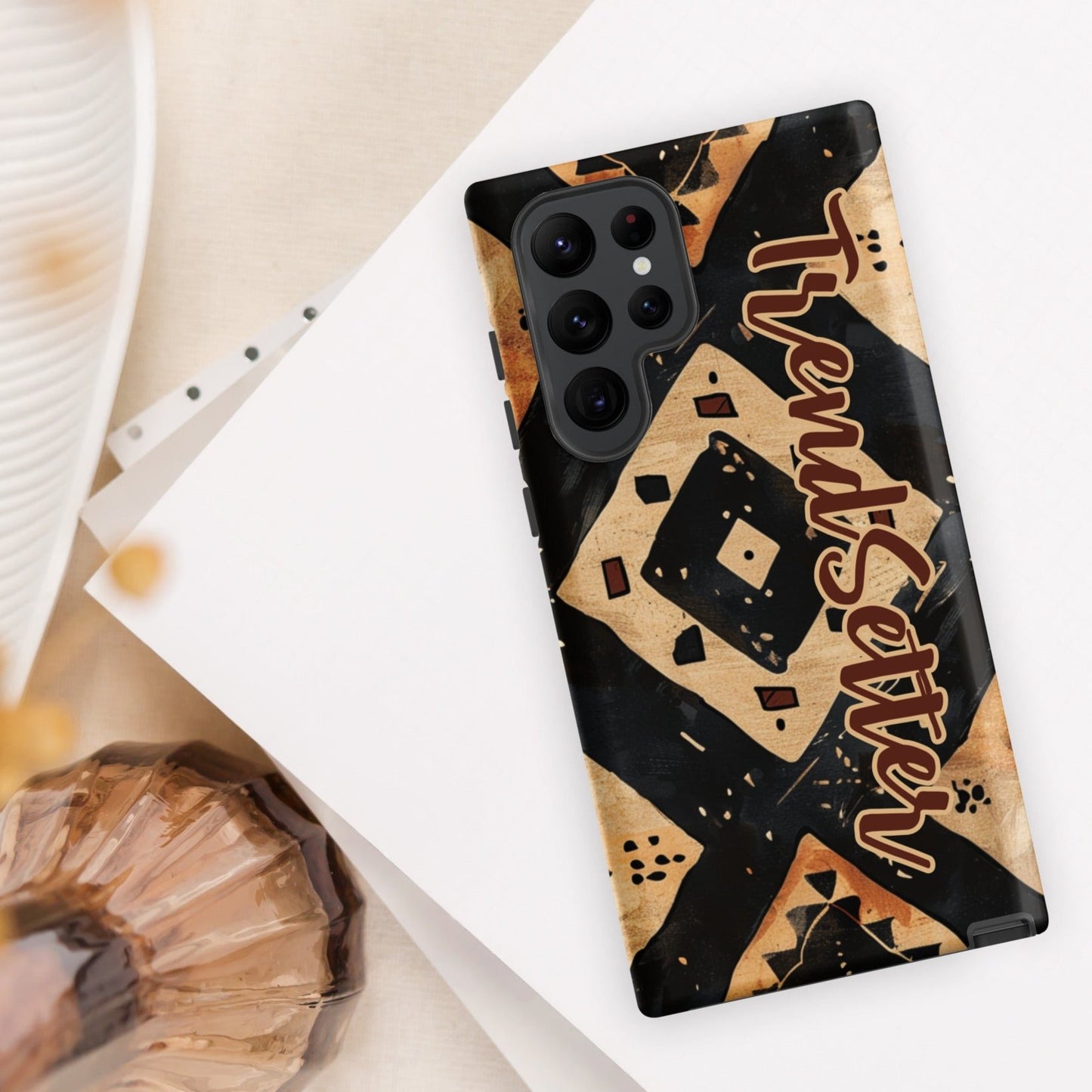 Front of TrendSetter Mother Land Roads 22 Samsung mobile cover with black and beige pattern with brown text saying 'TrendSetter'