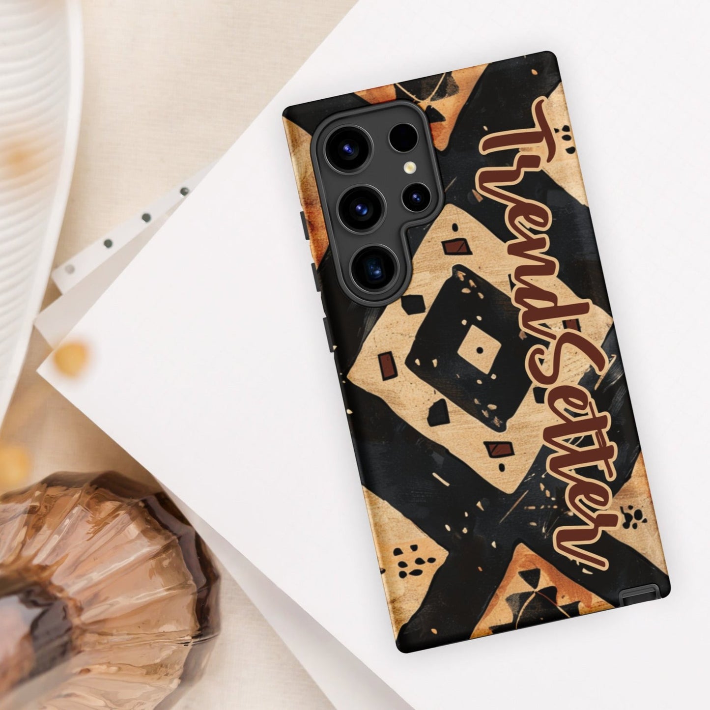 Front of TrendSetter Mother Land Roads 24 Samsung mobile cover with black and beige pattern with brown text saying 'TrendSetter'