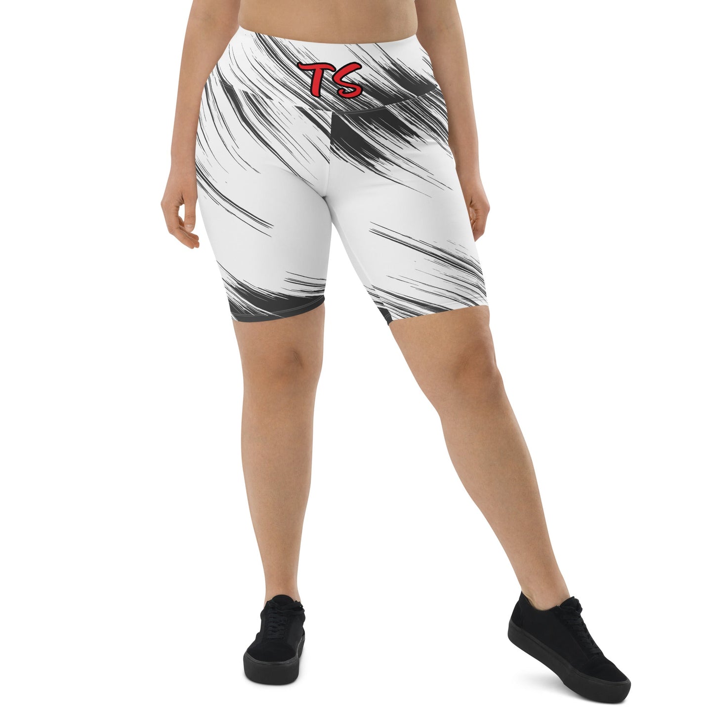 Lower front view of woman wearing black and white biker shorts with red text saying 'TS' on the waistband