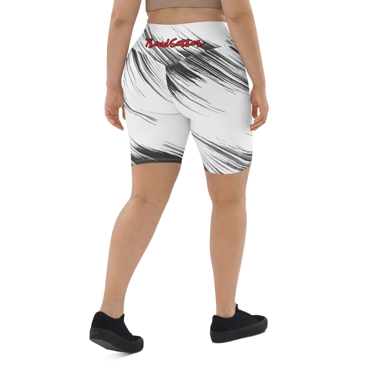 Back view of a woman wearing black and white biker shorts with red and black text saying 'TrendSetter' on the lower back