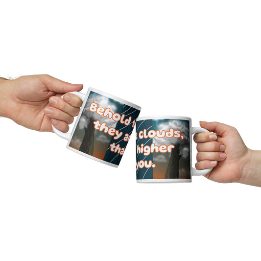 Side views of a white glossy mug cover in blue, brown, and orange cloud and tree image with text saying 'behold the clouds, they are higher than you'