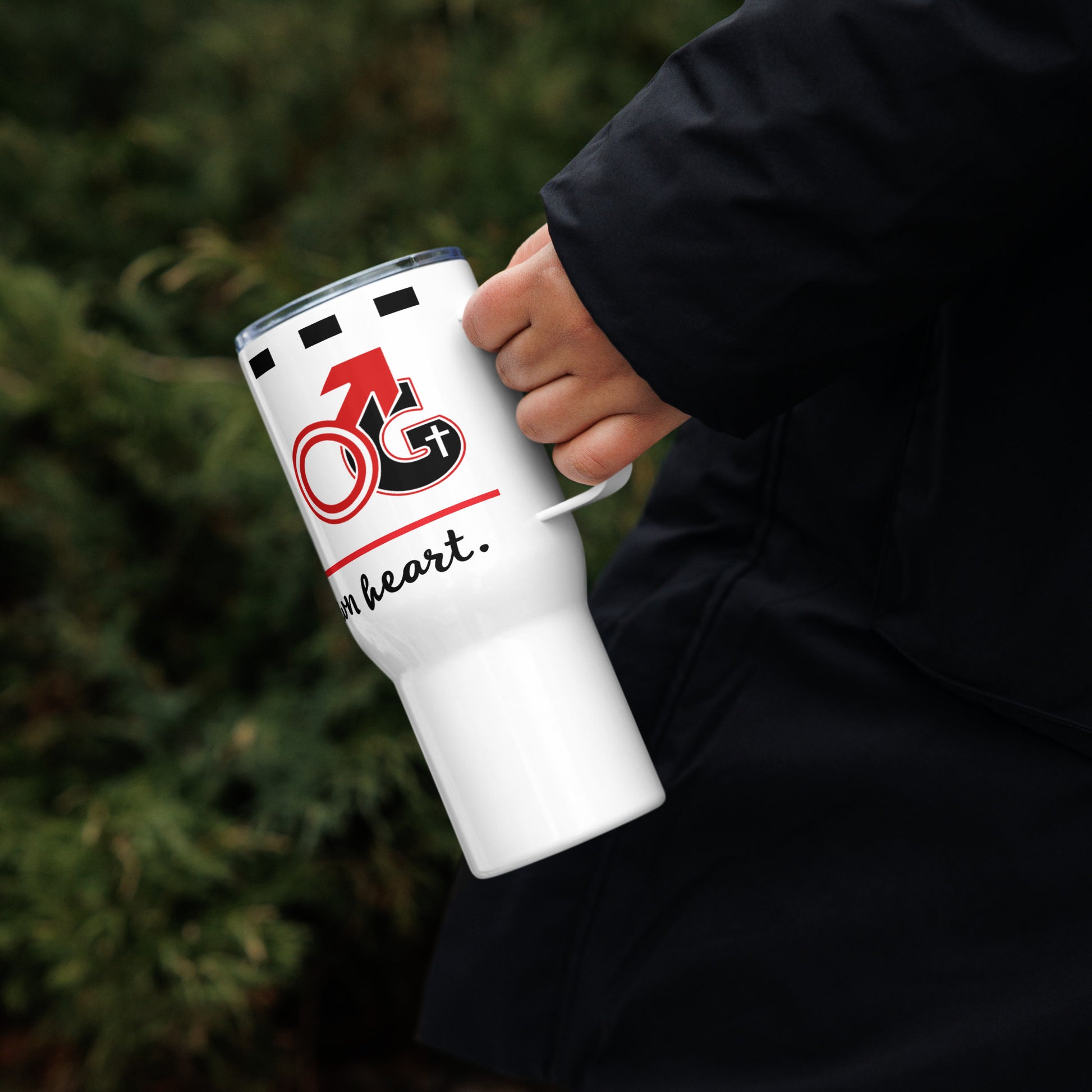 Hand holding a white travel mug with red and black 'Man of God' symbol and black text saying 'A man after God's own heart'