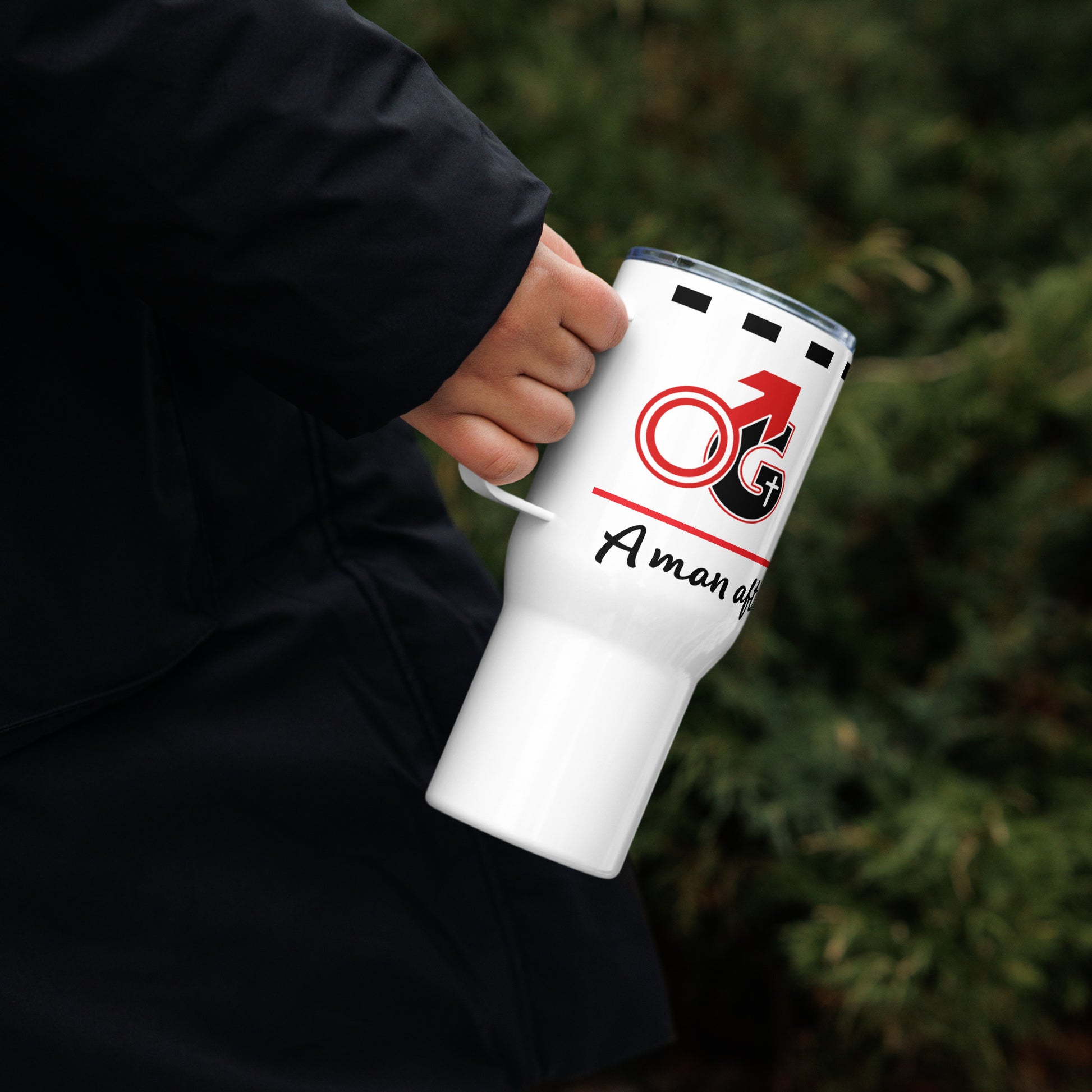 Hand holding a white travel mug with red and black 'Man of God' symbol and black text saying 'A man after God's own heart'