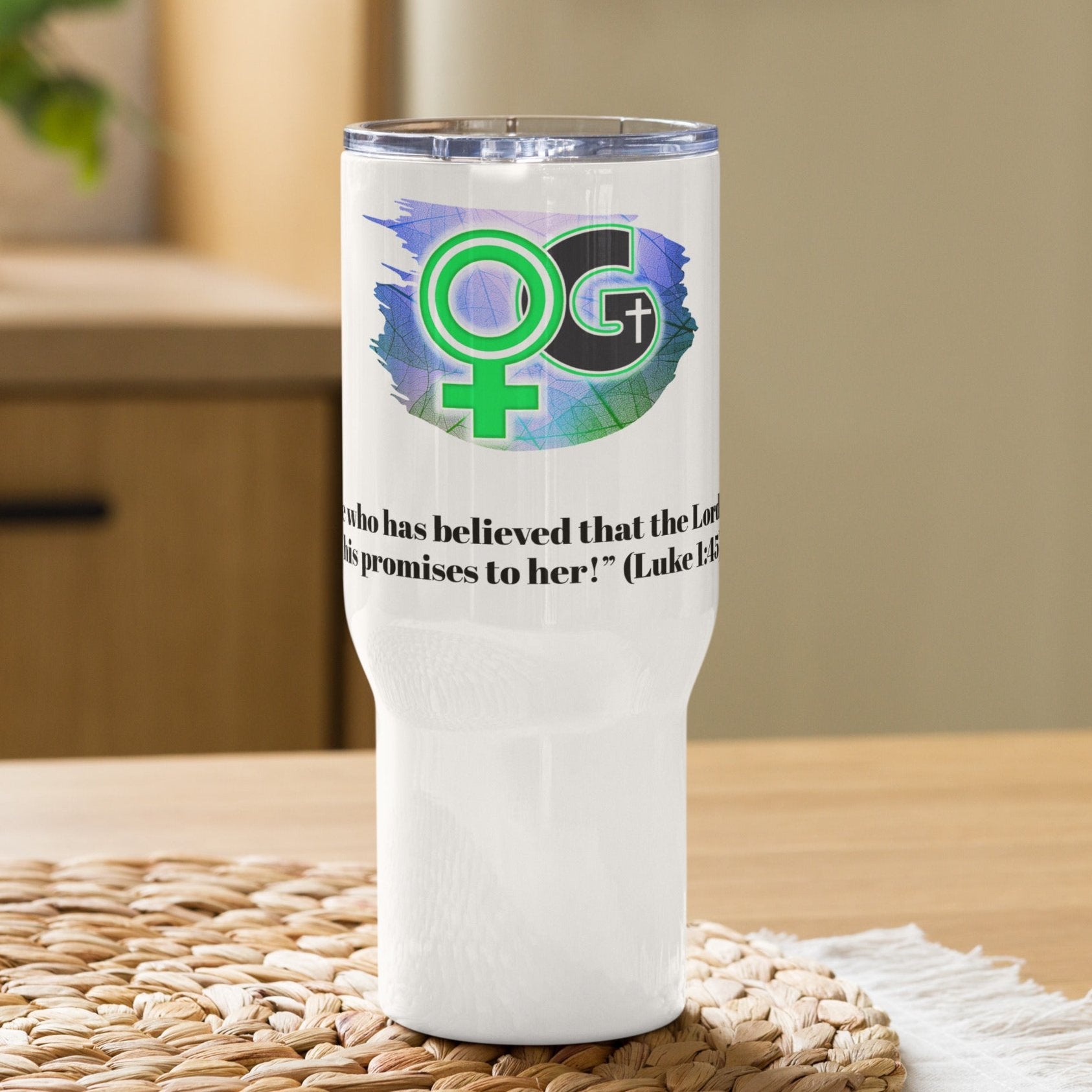 Front view of a white travel mug with green, white, and black image representing woman of God and black text from Luke 1:45 underneath