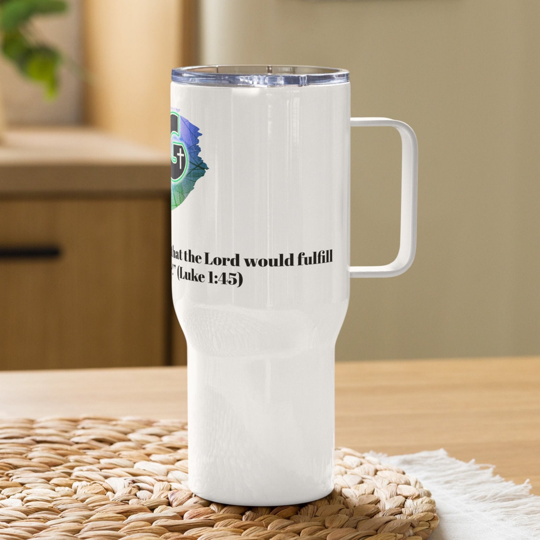 Right view of a white travel mug with partial view of the green, white, and black image representing woman of God and black text from Luke 1:45 underneath