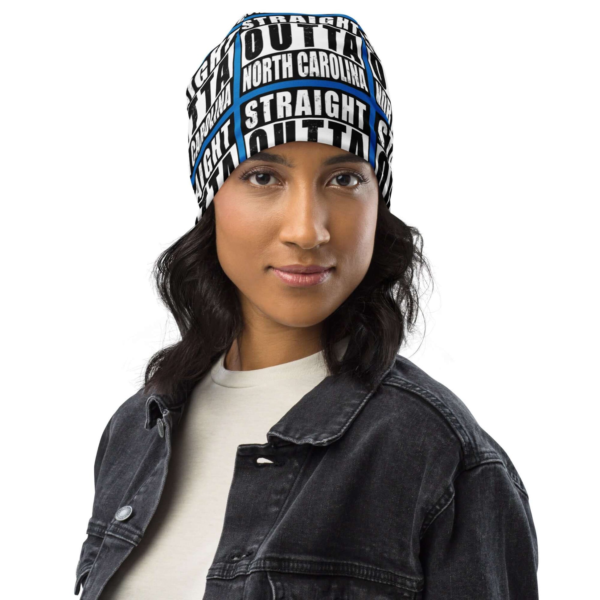 Woman wearing unisex beanie w/all-over print of the Straight Outta North Carolina image on a blue background, front view