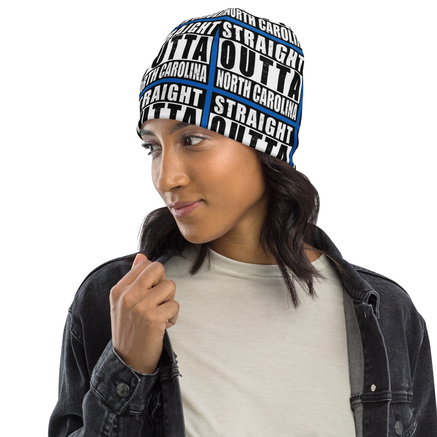 Woman wearing unisex beanie w/all-over print of the Straight Outta North Carolina image on a blue background, front left view