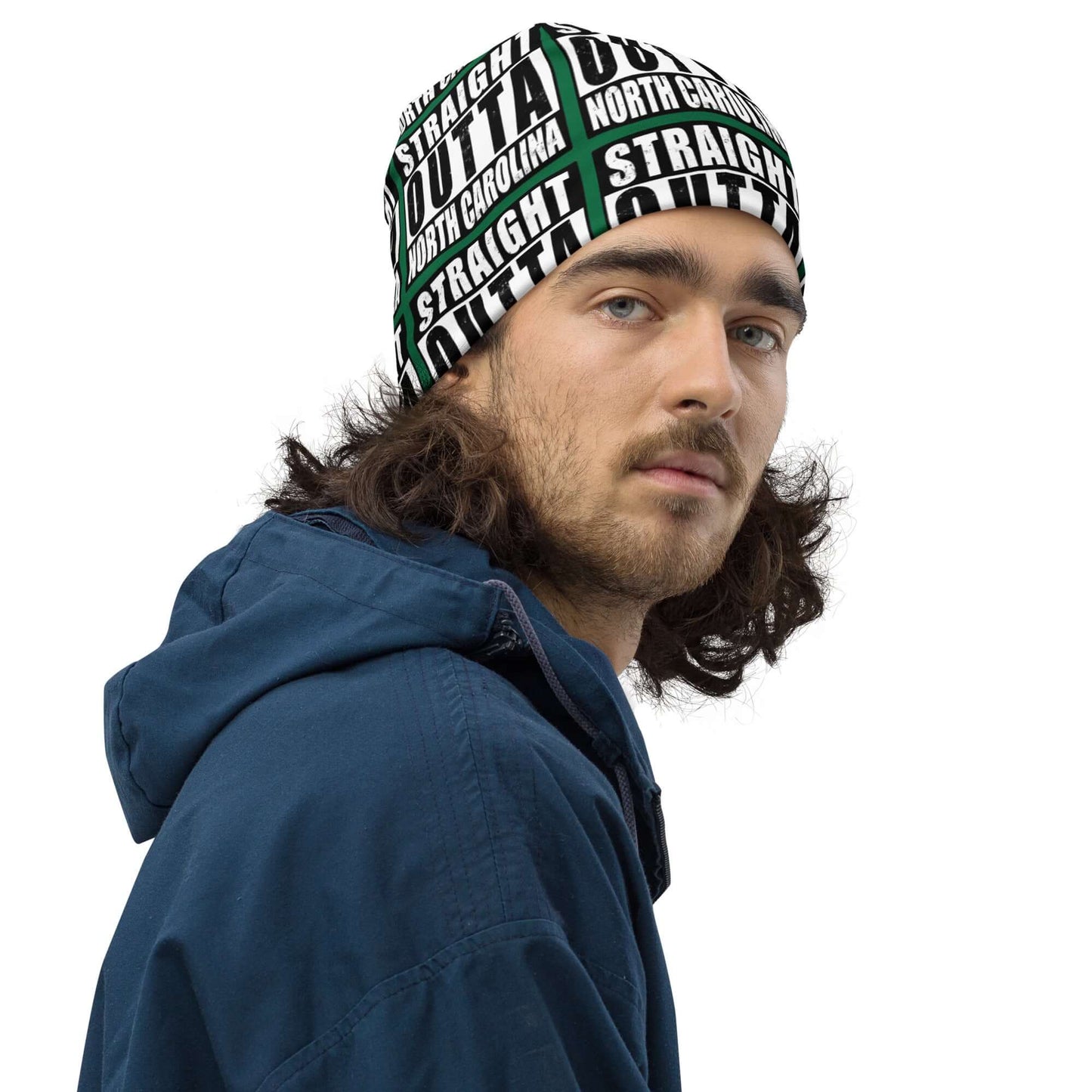 Man wearing unisex beanie w/all-over print of the Straight Outta North Carolina image on a green background, front right view