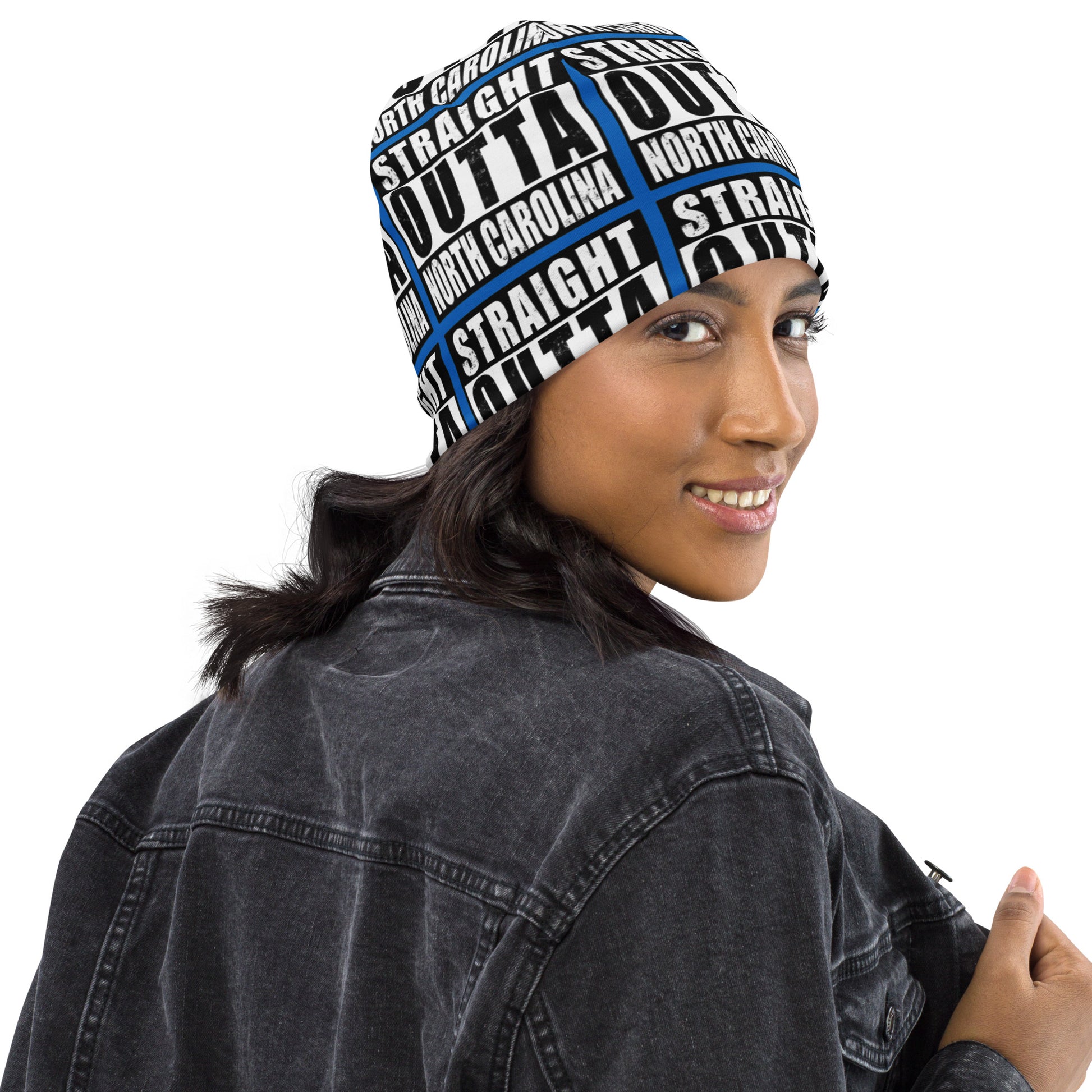 Woman wearing unisex beanie w/all-over print of the Straight Outta North Carolina image on a blue background, front right view