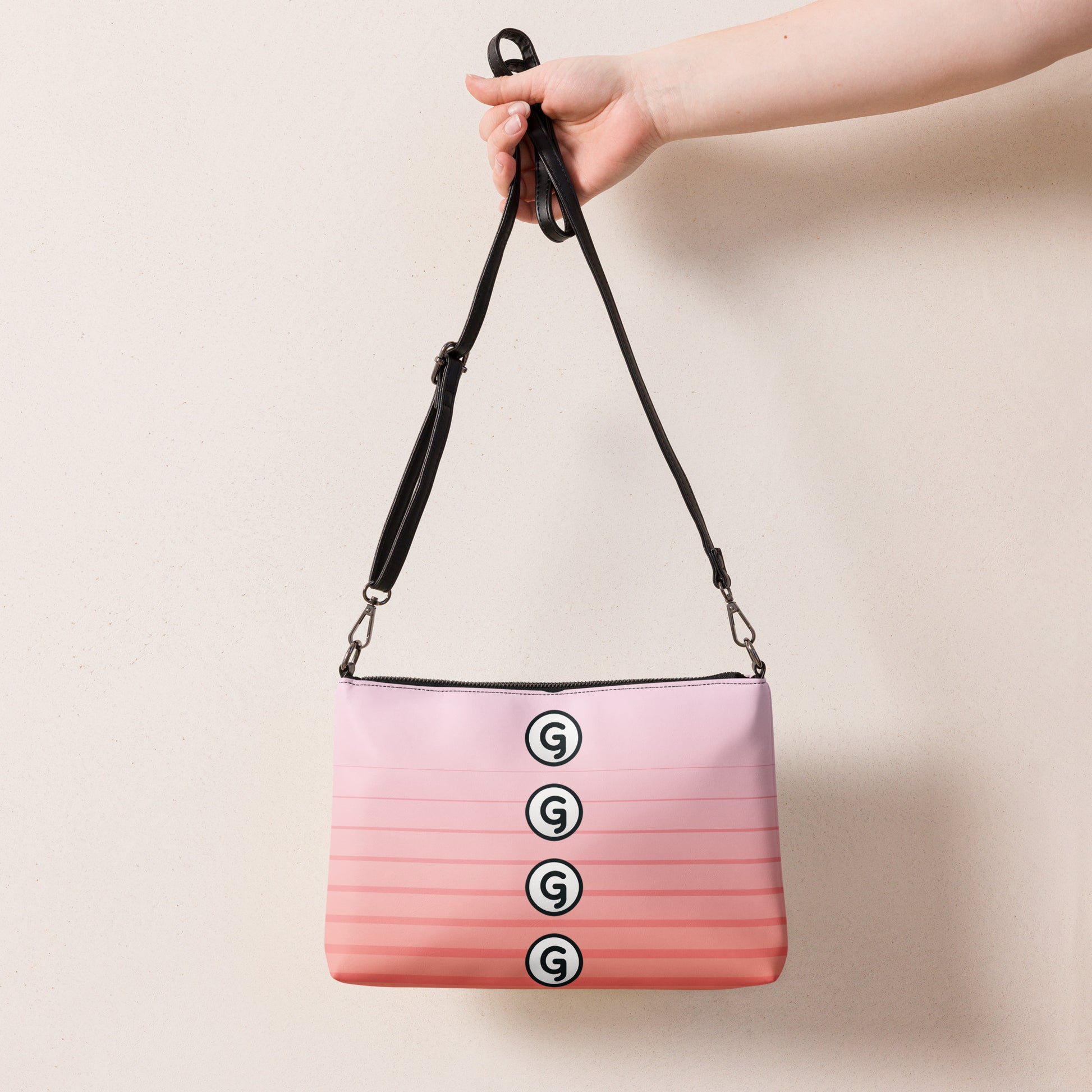 Back of crossbody bag with pink lined print being held