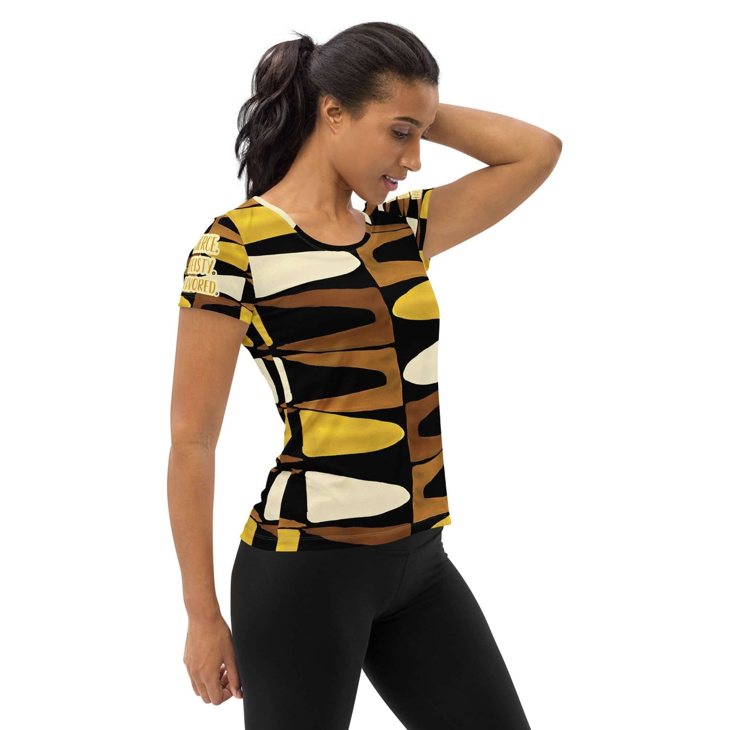 Half body front, right-side view of a woman wearing the Fierce. Feisty. Favored. black, brown, beige and gold print short sleeved t-shirt