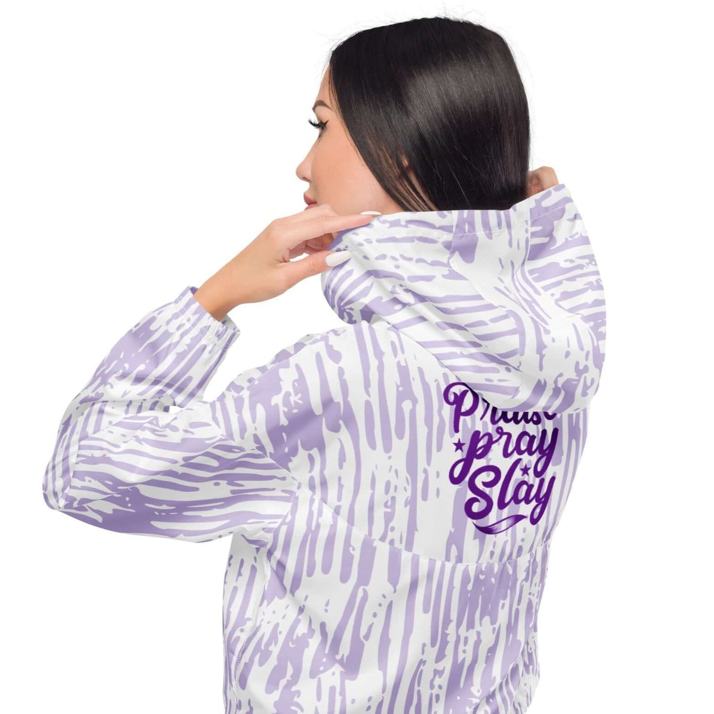 Back view of woman wearing a cropped purple and white windbreaker with text saying Praise Pray Slay